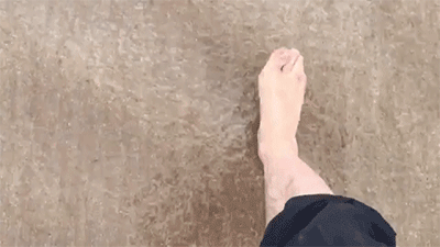 animated feet walking in shallow sea from above