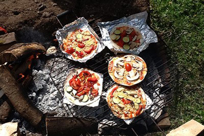 pizzas cooking on open fire